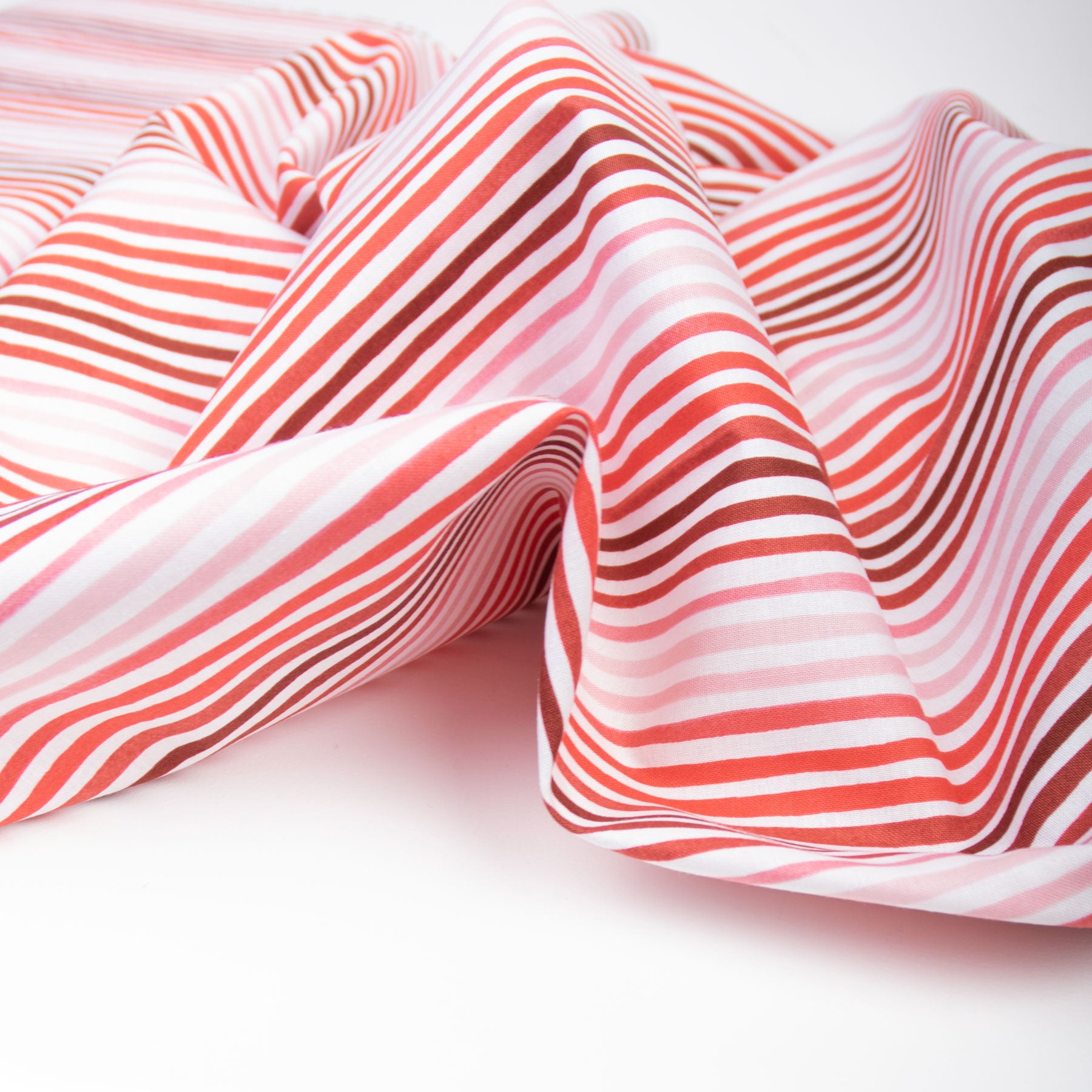 Red and white striped quilting fabric laid out on a white surface.